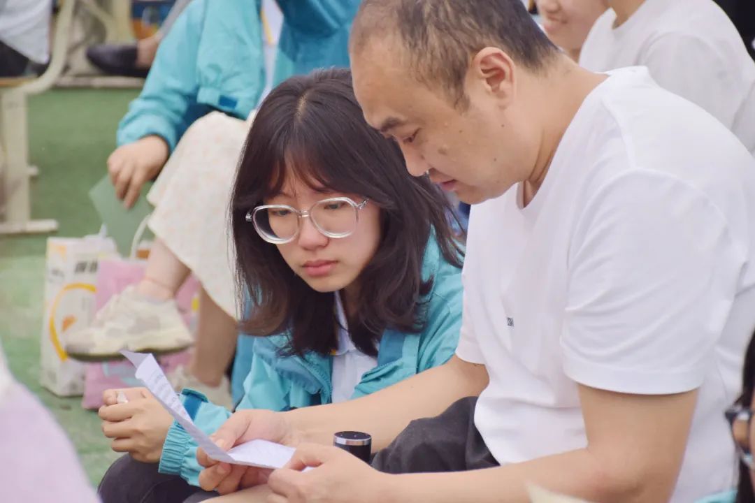 家长们读着孩子们写的一封封书信.jpg